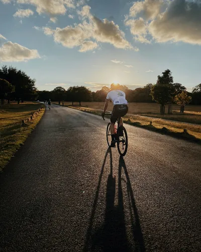 Cykelrytter på en landevej i aftensol