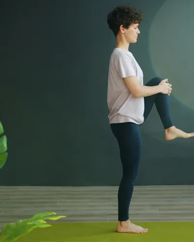 Kvinde der laver yoga på en grøn måtte
